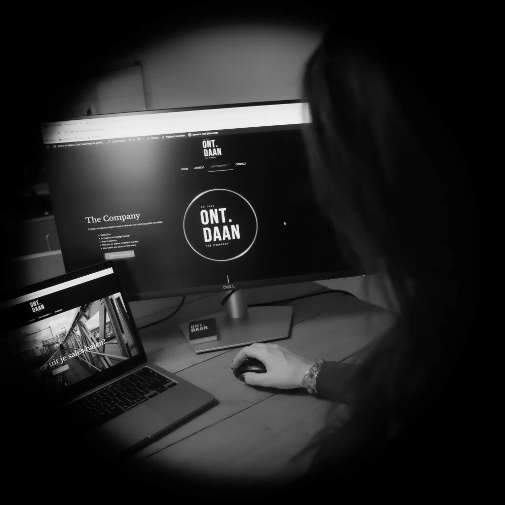 Zwart wit foto van Danielle aan het werk achter de computer